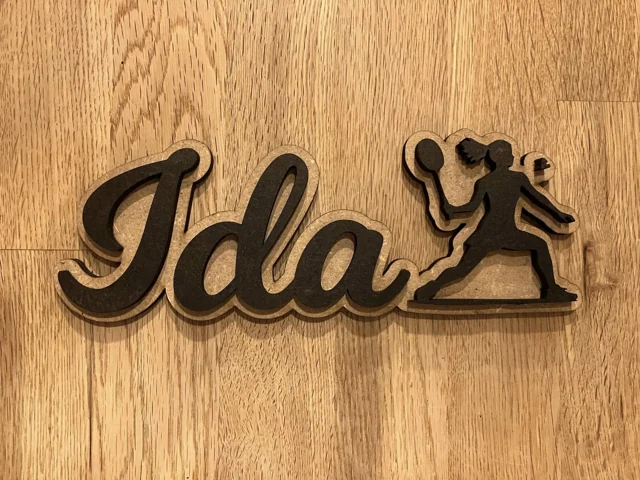 Navnet Ida udskåret sammen med en badmintonspiller i to lag